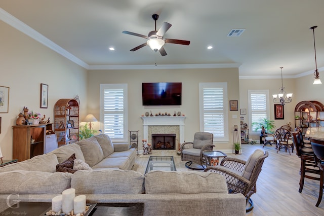 living room featuring crown molding, a healthy amount of sunlight, ceiling fan with notable chandelier, and light wood-type flooring