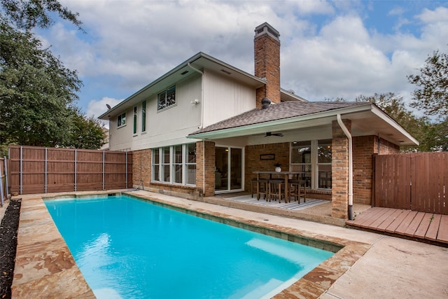 back of property with a patio, ceiling fan, and a pool side deck