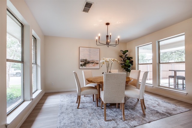 dining space featuring a chandelier, a wealth of natural light, and wood-type flooring