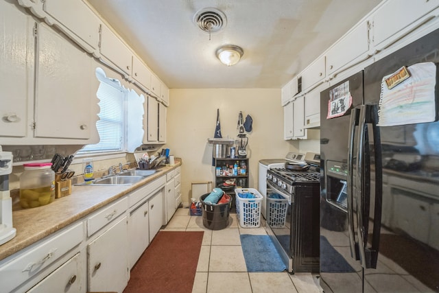 kitchen featuring black refrigerator with ice dispenser, gas stove, white cabinetry, and sink