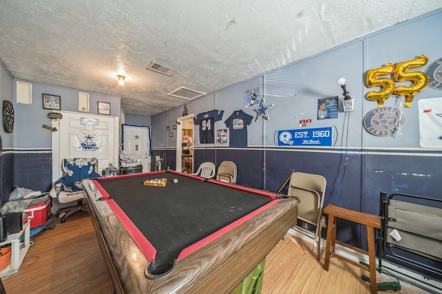 recreation room featuring pool table, hardwood / wood-style floors, and a textured ceiling