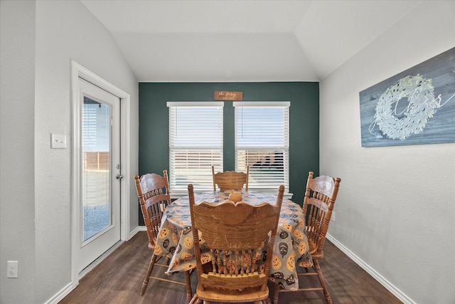 dining space with dark hardwood / wood-style flooring and vaulted ceiling