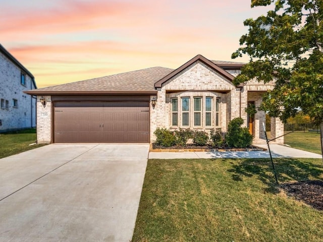 view of front of home with a garage and a lawn