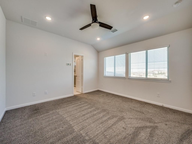 spare room with visible vents, a healthy amount of sunlight, carpet, and lofted ceiling