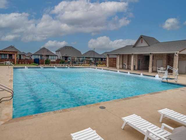 pool featuring a patio area, a residential view, and fence