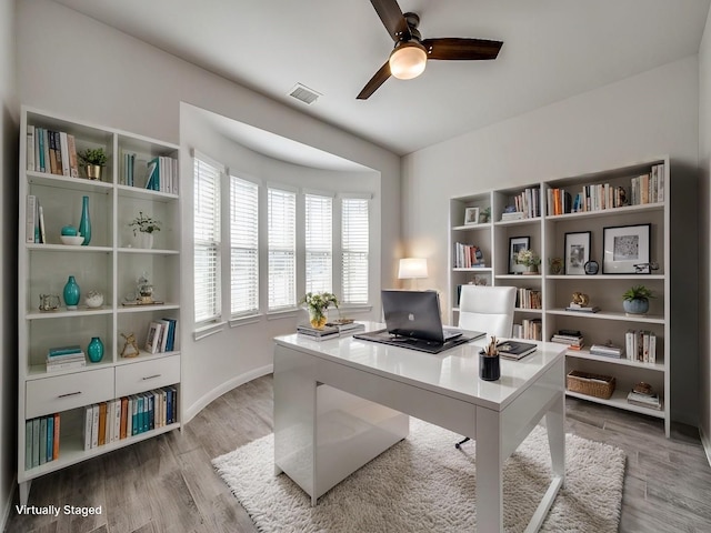 office area with light wood-type flooring, visible vents, baseboards, and ceiling fan