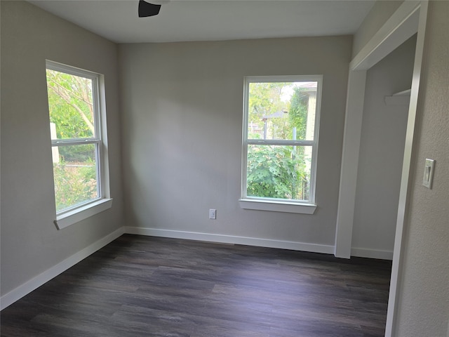 spare room with dark wood-type flooring and ceiling fan