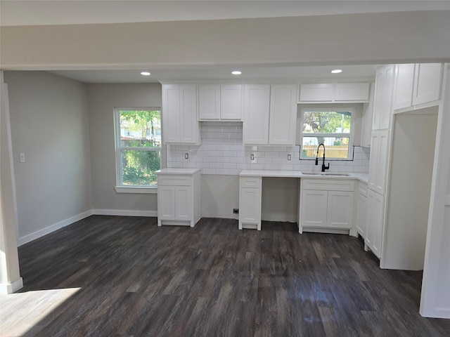 3107 51st St, Dallas, TX 75216 - kitchen featuring a sink, dark wood-style flooring, white cabinets, decorative backsplash, and baseboards