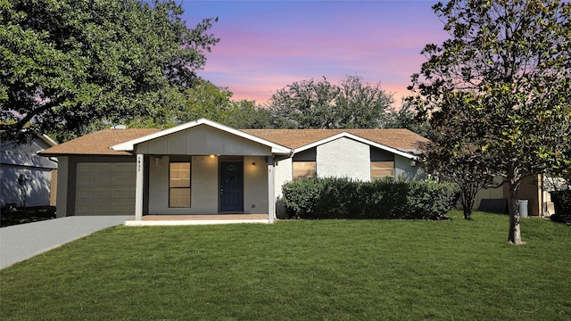 ranch-style house with a garage and a lawn