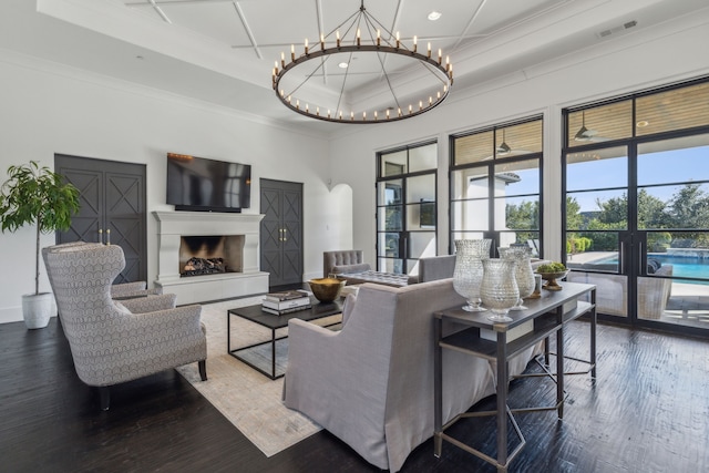 living room featuring a tray ceiling, a towering ceiling, dark wood-type flooring, and ornamental molding