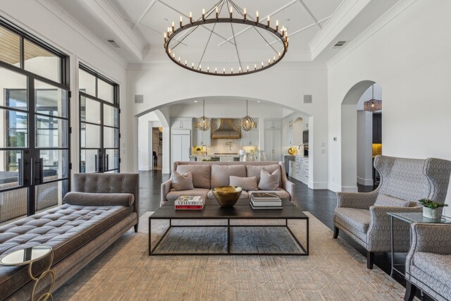 living room featuring hardwood / wood-style flooring, ornamental molding, a high ceiling, and french doors