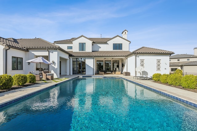 rear view of property featuring ceiling fan and a patio area