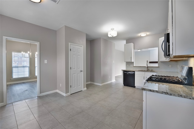 kitchen featuring sink, stainless steel stove, black dishwasher, light stone counters, and white cabinetry