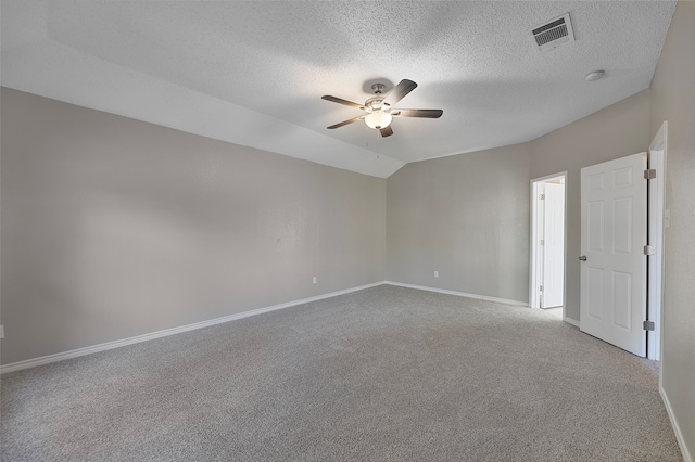 carpeted empty room featuring a textured ceiling, vaulted ceiling, and ceiling fan