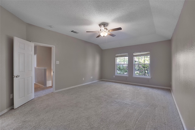 unfurnished room with a textured ceiling, light colored carpet, ceiling fan, and lofted ceiling