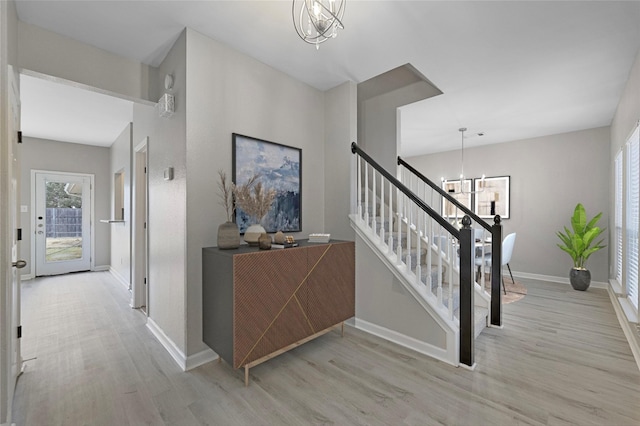 stairs featuring hardwood / wood-style floors and a notable chandelier