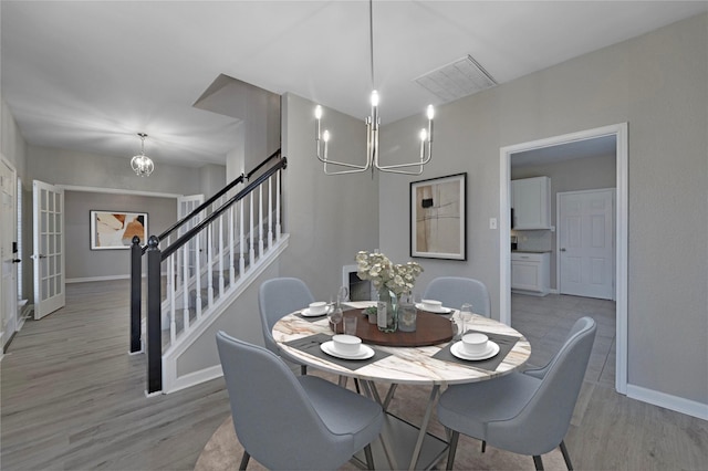 dining room featuring a chandelier, french doors, and light hardwood / wood-style flooring