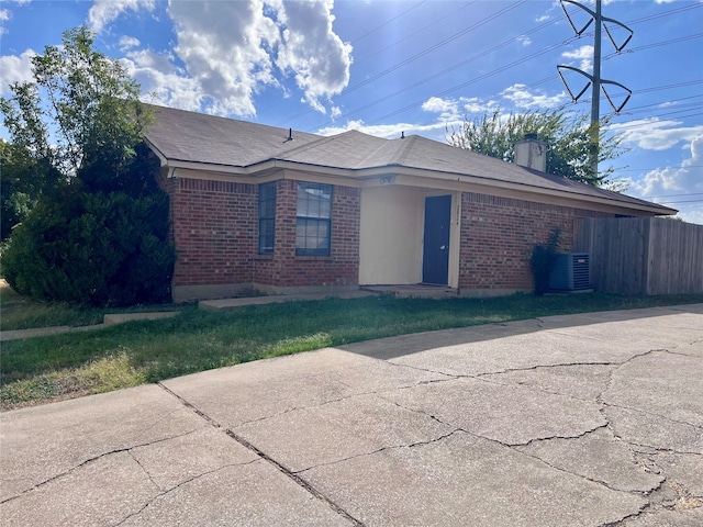 view of front of property featuring central AC and a front yard