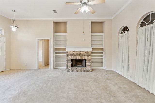 unfurnished living room with built in features, a brick fireplace, light carpet, ceiling fan, and crown molding