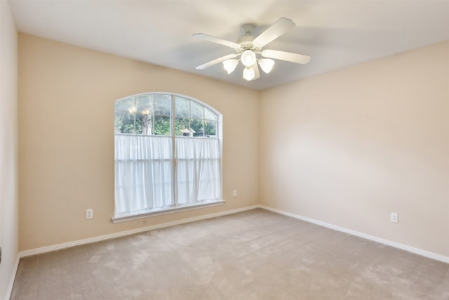 carpeted spare room with ceiling fan