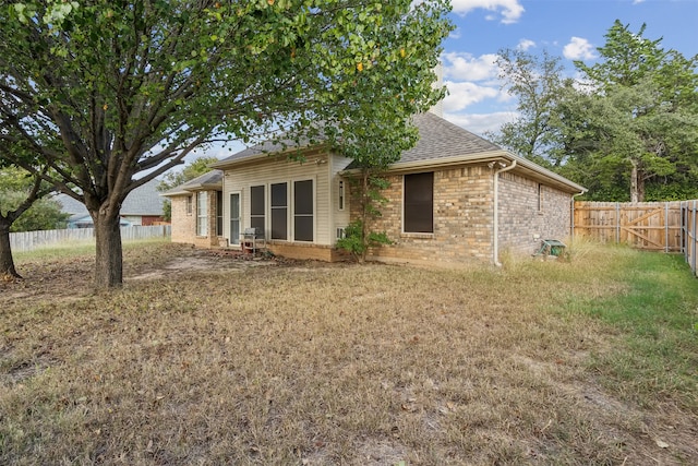 back of property featuring a yard