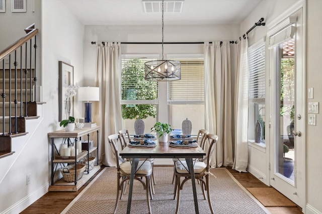 dining space with a wealth of natural light, a chandelier, and hardwood / wood-style flooring