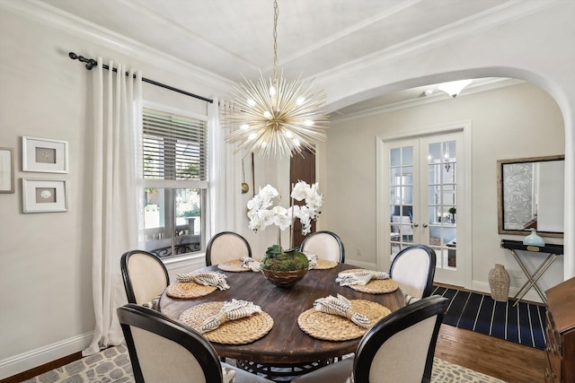 dining room with french doors, a notable chandelier, crown molding, and hardwood / wood-style floors