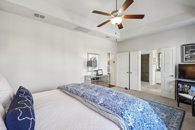 bedroom featuring ceiling fan, ensuite bathroom, and light carpet