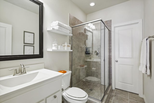 bathroom with a shower with shower door, tile patterned floors, vanity, and toilet