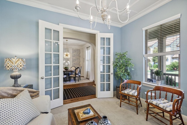 interior space featuring light colored carpet, french doors, a chandelier, and ornamental molding