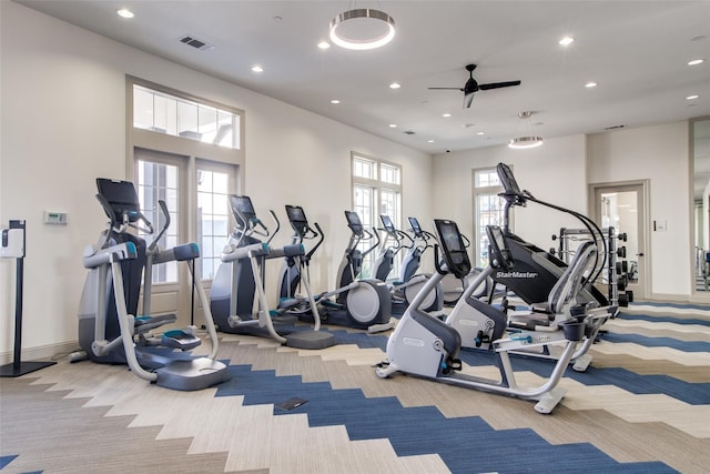 workout area featuring ceiling fan and light colored carpet