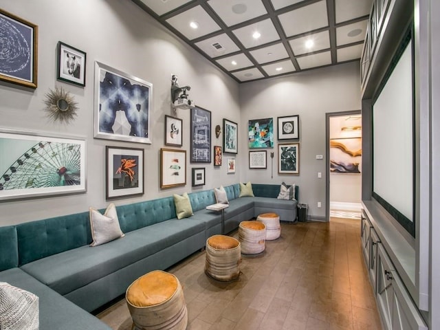 living room with dark hardwood / wood-style floors, a towering ceiling, coffered ceiling, and beamed ceiling