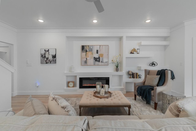 living room featuring light hardwood / wood-style floors, ceiling fan, and ornamental molding