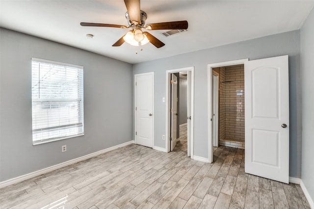 unfurnished bedroom featuring a spacious closet, ceiling fan, light hardwood / wood-style flooring, and ensuite bath