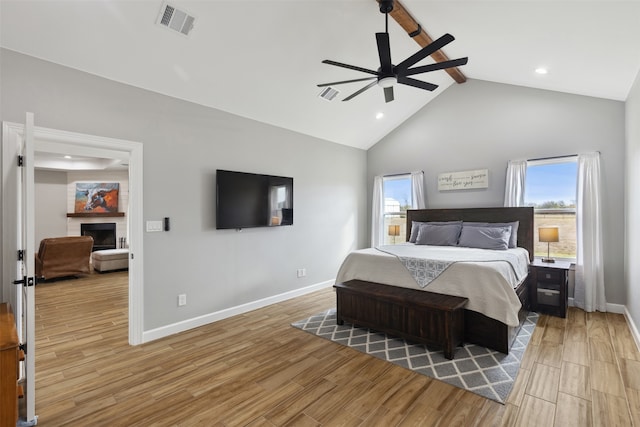 bedroom featuring beamed ceiling, light hardwood / wood-style flooring, high vaulted ceiling, and ceiling fan