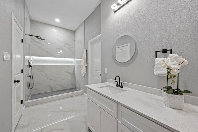 bathroom with vanity and tiled shower