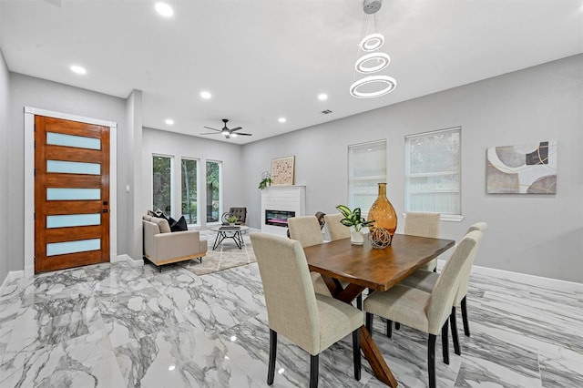 dining space with ceiling fan with notable chandelier