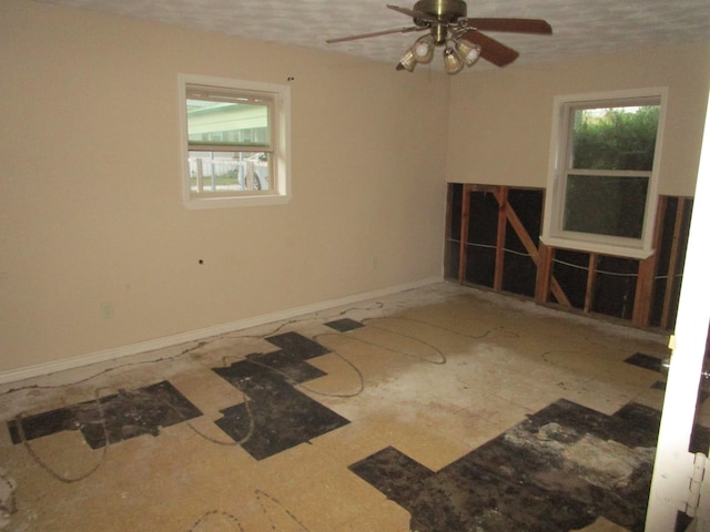 unfurnished room with ceiling fan and a textured ceiling