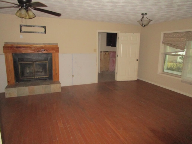 unfurnished living room with ceiling fan, a textured ceiling, a fireplace, and hardwood / wood-style floors