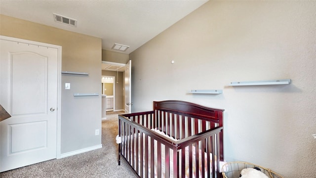 bedroom featuring light carpet and a nursery area