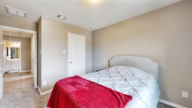 carpeted bedroom featuring ensuite bath