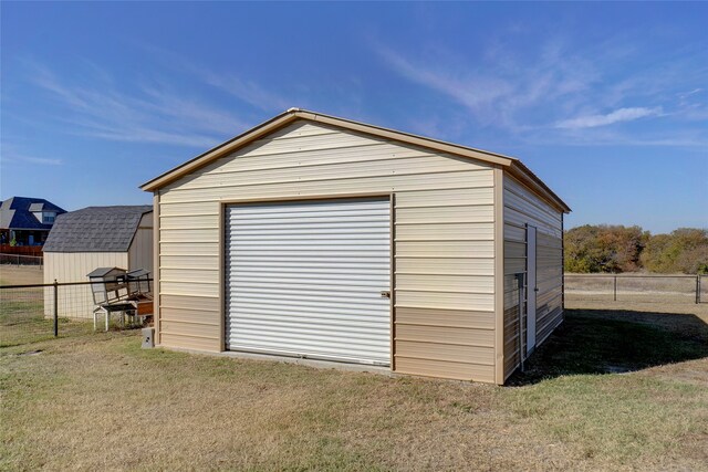 view of outdoor structure with a garage and a lawn