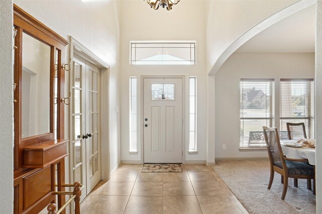 foyer with a towering ceiling and light tile patterned floors