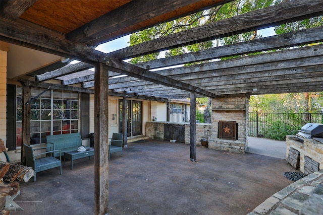 view of patio / terrace featuring a pergola, a grill, an outdoor kitchen, and an outdoor stone fireplace