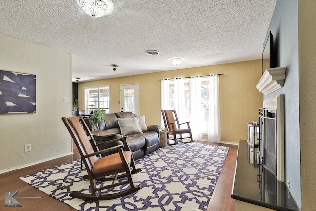 living room with dark wood-type flooring and a textured ceiling