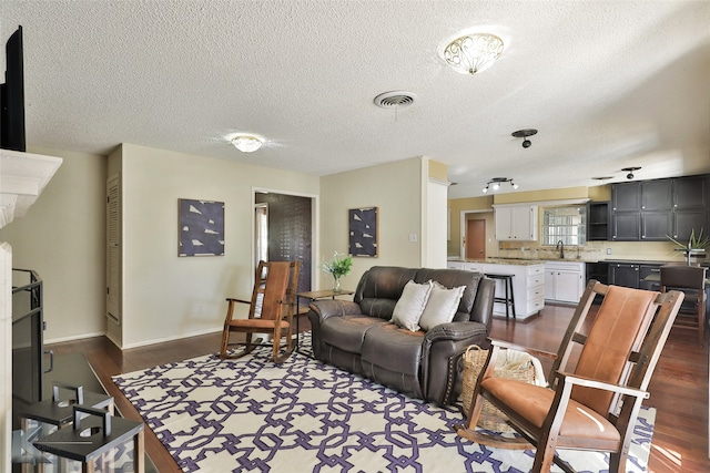 living room with a textured ceiling and dark wood-type flooring