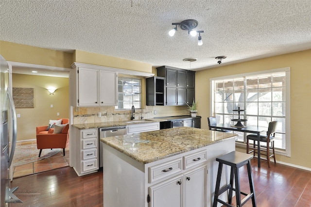 kitchen featuring white cabinets, a center island, stainless steel appliances, and sink