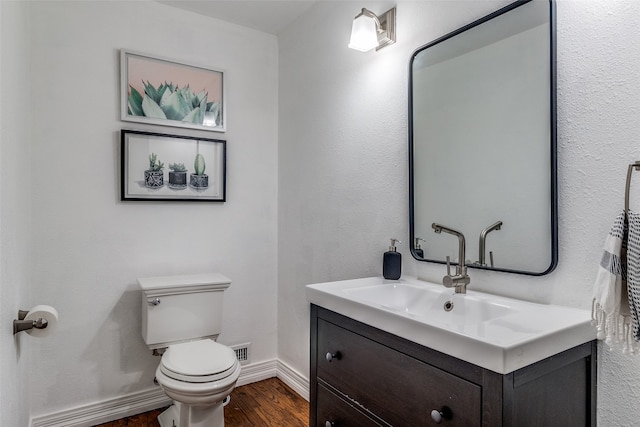 bathroom featuring vanity, hardwood / wood-style floors, and toilet