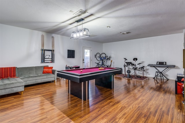 playroom featuring a textured ceiling, pool table, and hardwood / wood-style floors