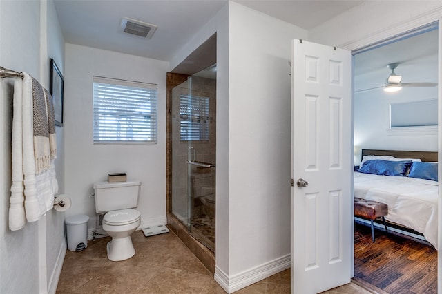 bathroom featuring a shower with door, tile patterned floors, toilet, and ceiling fan